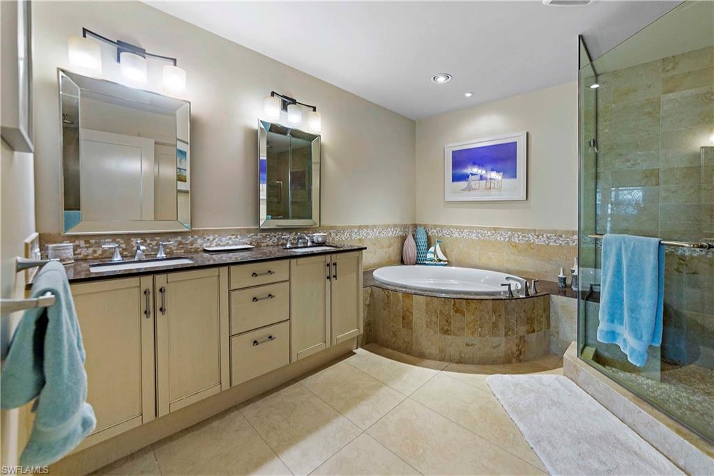9115 Strada Place, Unit 5501 Naples, FL 34108 - Photo 12 of 31 a spacious bathroom with a granite countertop sink a mirror and a bathtub