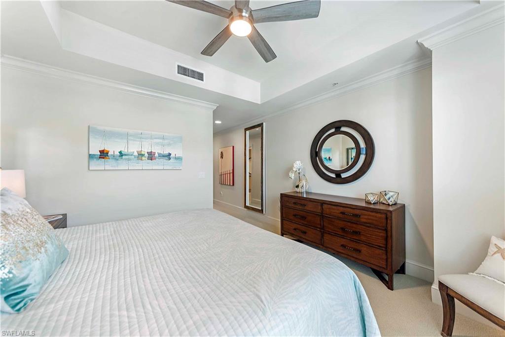 9115 Strada Place, Unit 5501 Naples, FL 34108 - Photo 13 of 31 a bedroom with a bed and a chandelier