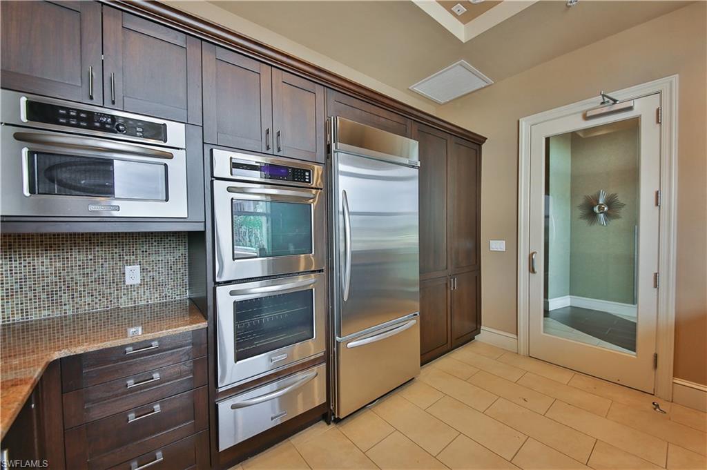 9115 Strada Place, Unit 5501 Naples, FL 34108 - Photo 16 of 31 a kitchen with granite countertop white cabinets and stainless steel appliances