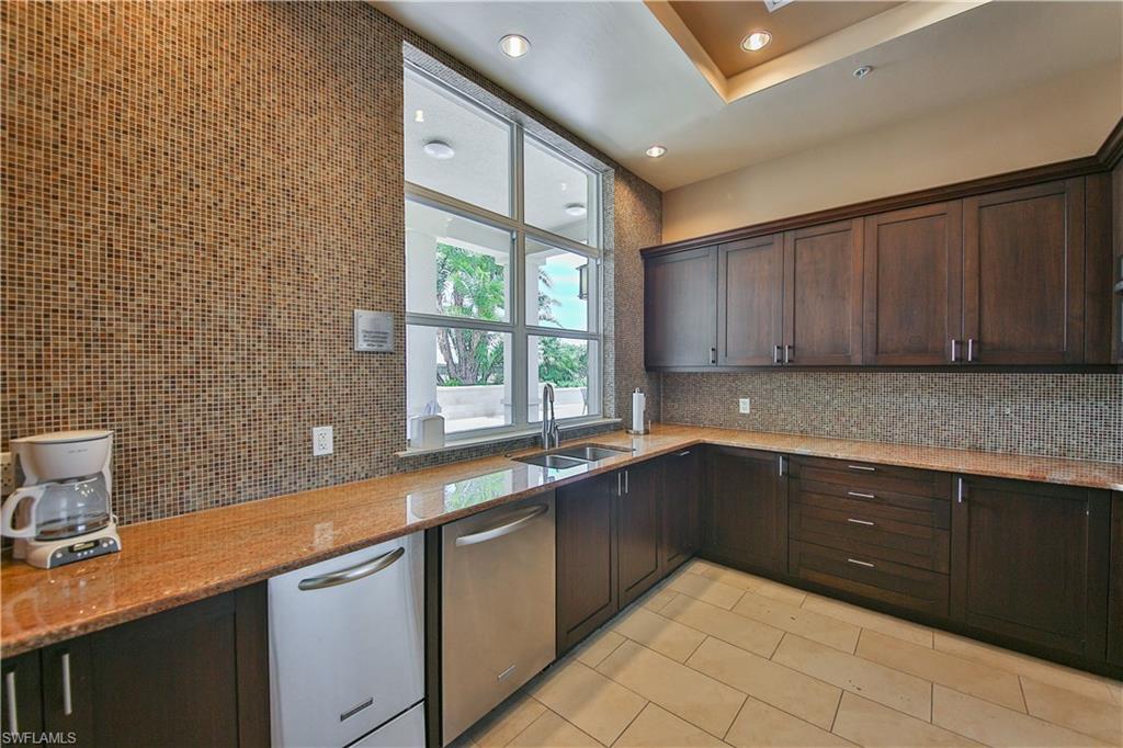 9115 Strada Place, Unit 5501 Naples, FL 34108 - Photo 17 of 31 a kitchen with a sink and cabinets