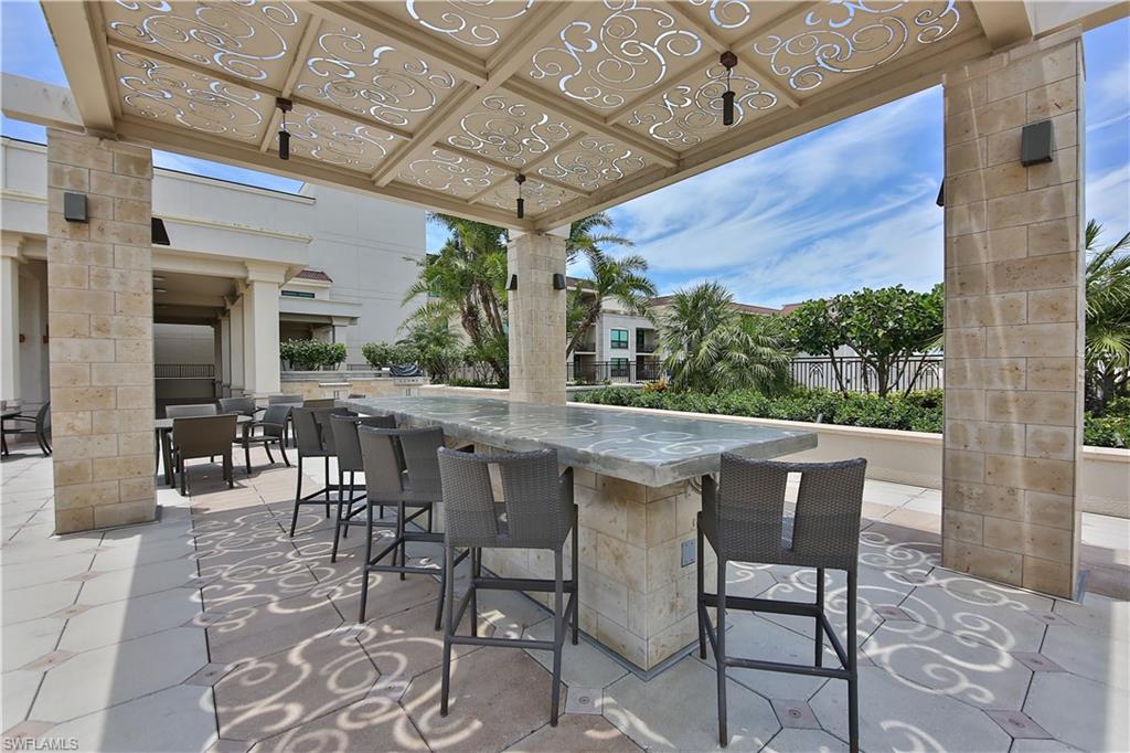 9115 Strada Place, Unit 5501 Naples, FL 34108 - Photo 18 of 31 a dining room with furniture and a floor to ceiling window