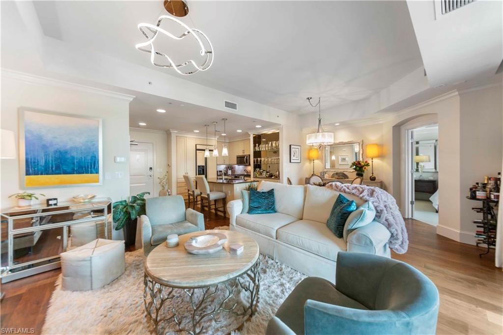 9115 Strada Place, Unit 5501 Naples, FL 34108 - Photo 4 of 31 a living room with furniture kitchen view and a chandelier