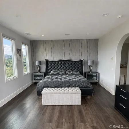a bedroom with a large bed and a painting on the wall