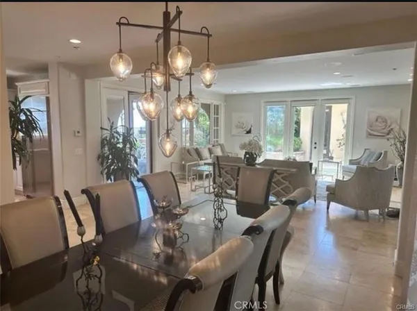 a dining room with furniture a chandelier and wooden floor