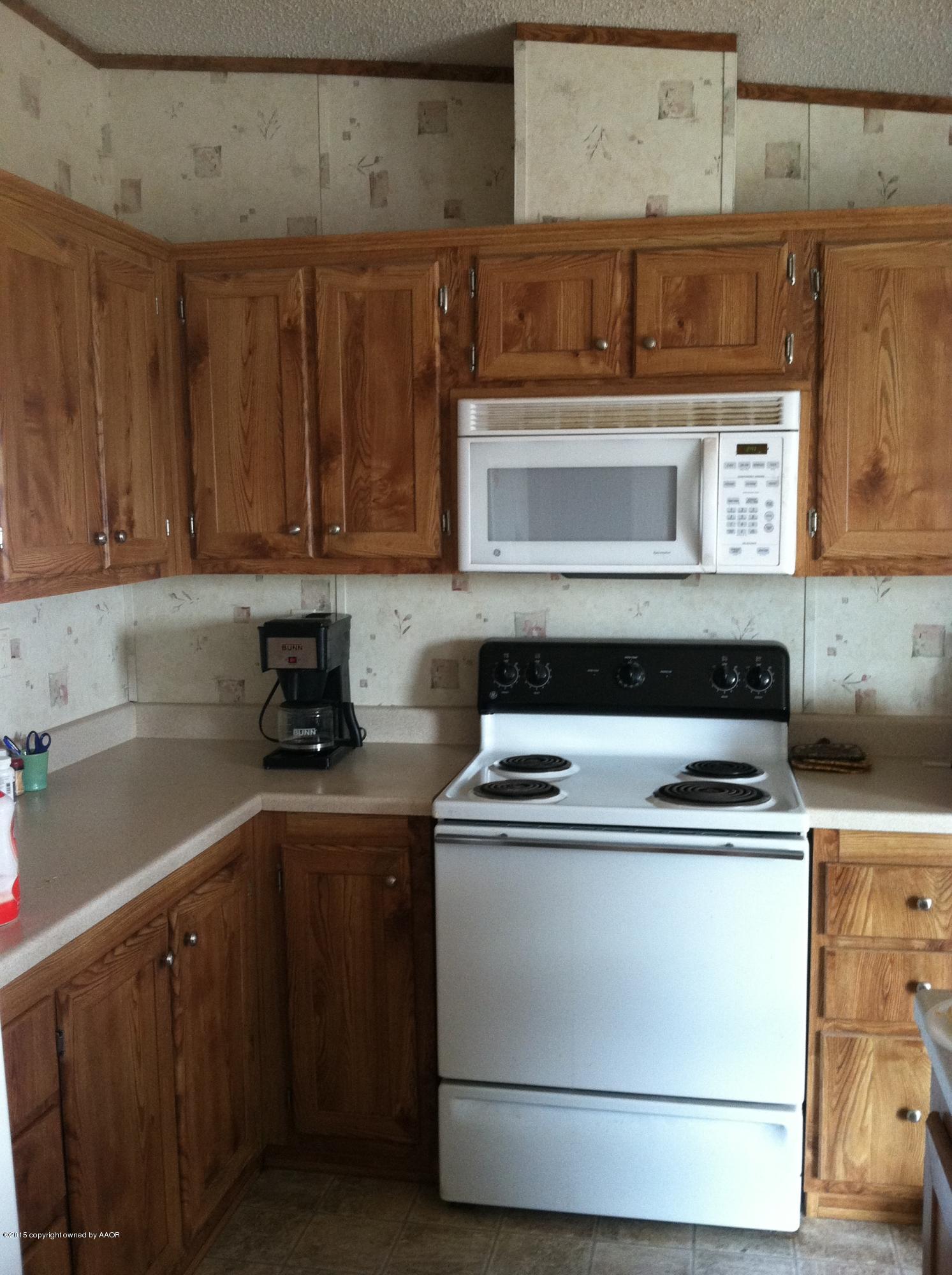 91 Chattanooga Road Amarillo, TX 79118 - Photo 8 of 28 a kitchen with wooden cabinets and a stove top oven