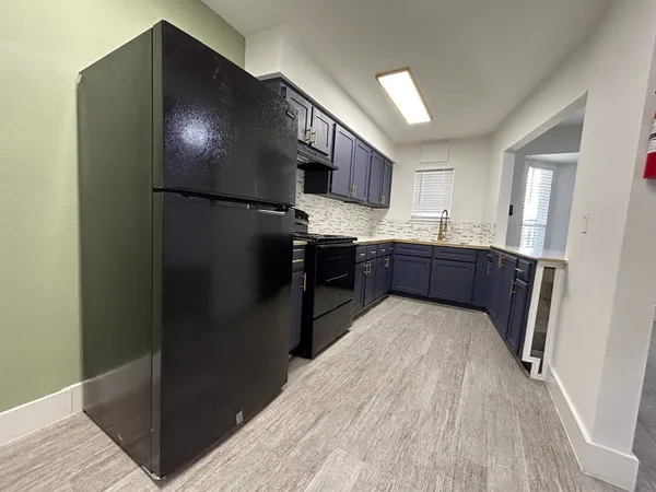 a kitchen with stainless steel appliances granite countertop a refrigerator and a sink