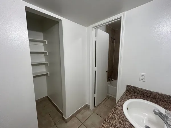 a bathroom with a granite countertop sink and a mirror