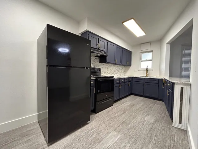 a kitchen with stainless steel appliances granite countertop a refrigerator and a sink