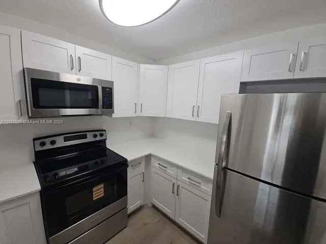 a kitchen with a refrigerator stove and microwave