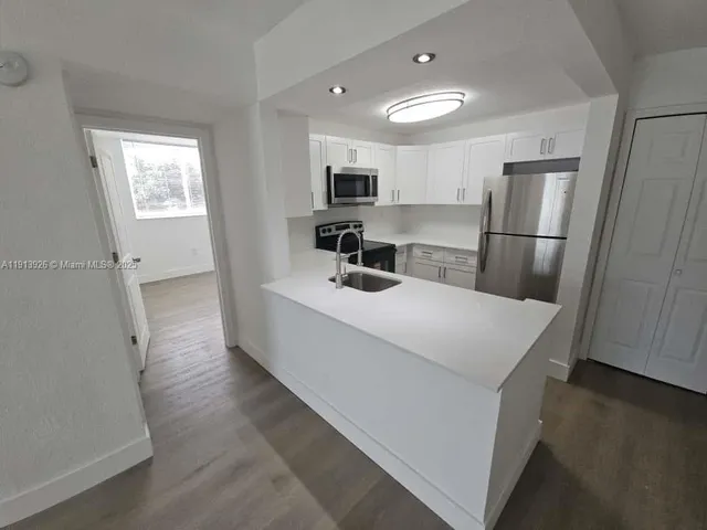a kitchen with stainless steel appliances a refrigerator and microwave