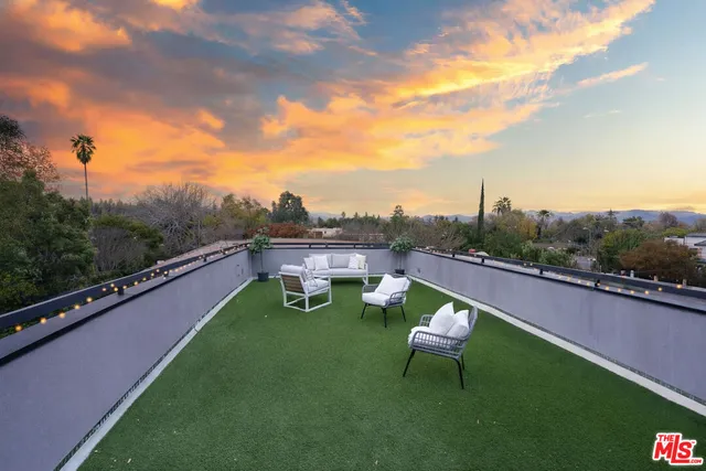 a swimming pool with outdoor seating and a garden