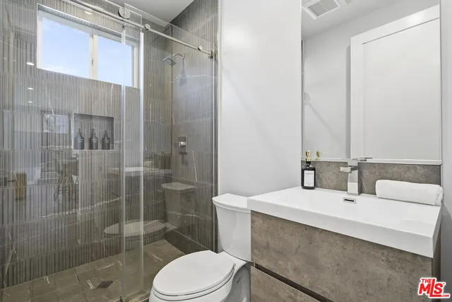 a bathroom with a sink mirror toilet and shower