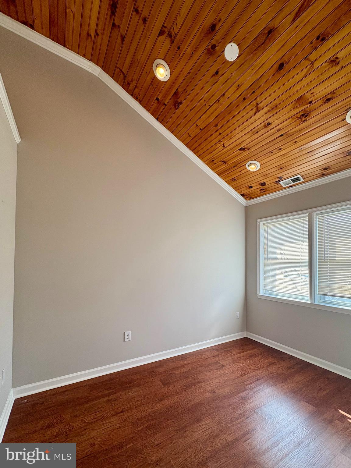 118 Wiltshire Road Baltimore, MD 21221 - Photo 4 of 10 a view of an empty room with wooden floor and a window