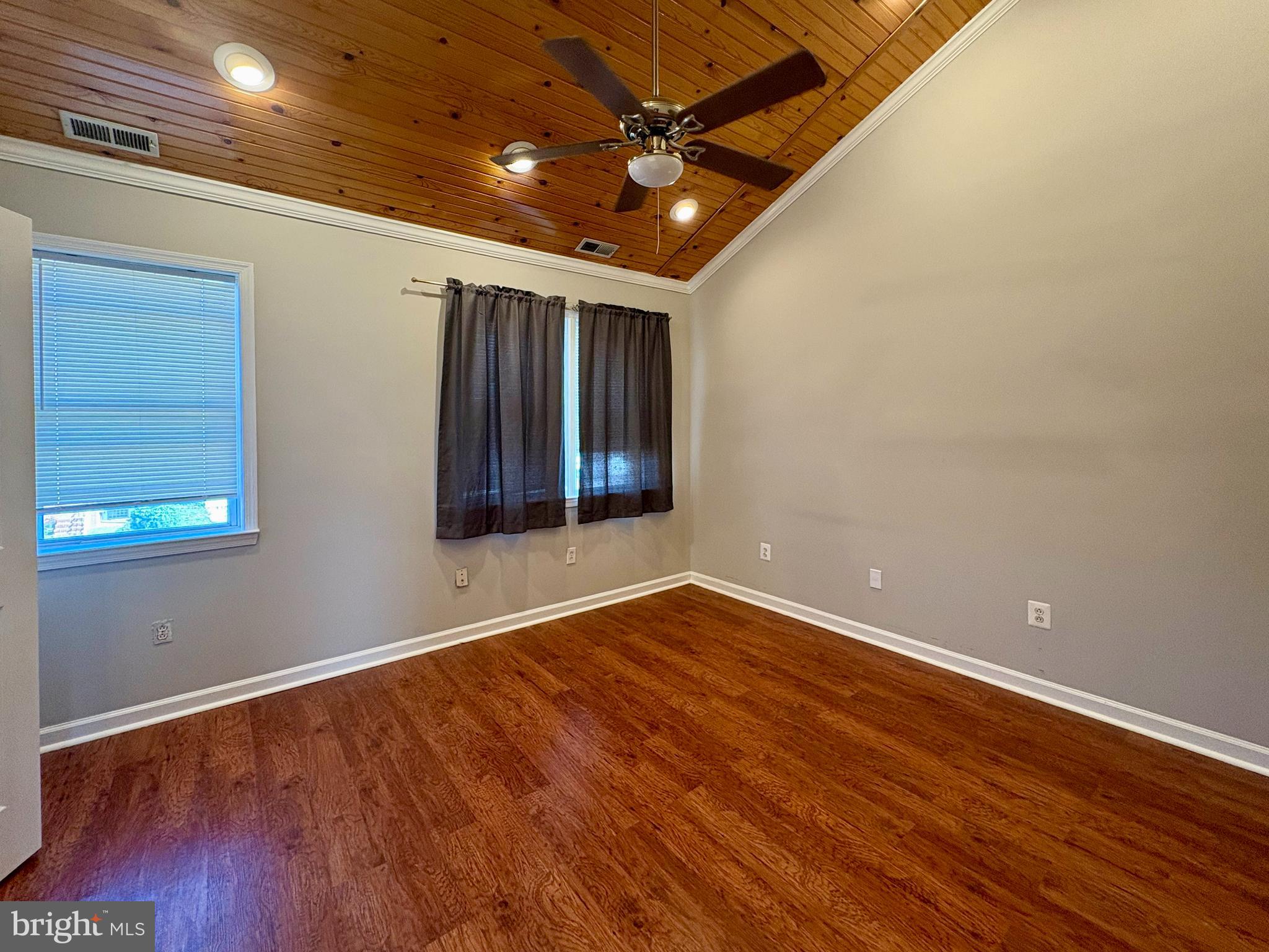 118 Wiltshire Road Baltimore, MD 21221 - Photo 7 of 10 an empty room with wooden floor and windows
