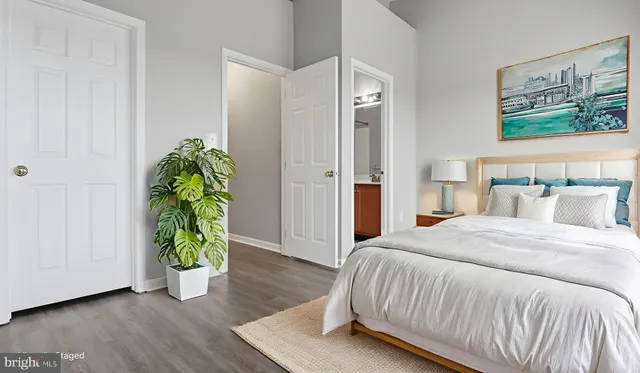 a view of an empty room with wooden floor and closet