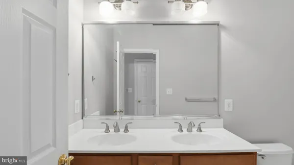 a bathroom with a toilet a sink a tub and mirror