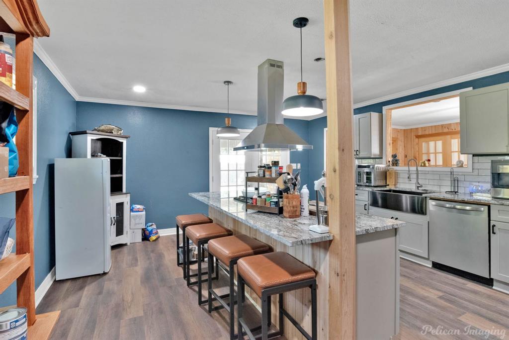 1100 Chipper Lane Keithville, LA 71047 - Photo 14 of 28 a kitchen with stainless steel appliances kitchen island granite countertop a refrigerator a stove top oven a sink dishwasher and white cabinets with wooden floor