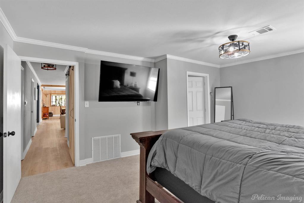 1100 Chipper Lane Keithville, LA 71047 - Photo 16 of 28 a bedroom with a bed and a chandelier