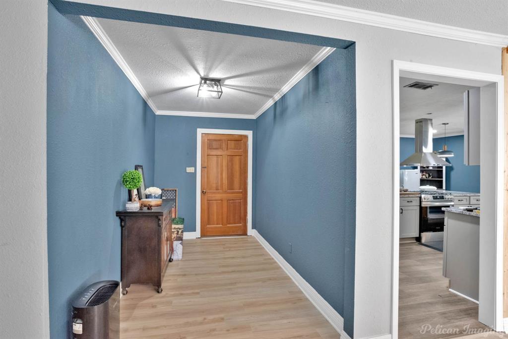 1100 Chipper Lane Keithville, LA 71047 - Photo 3 of 28 a view of a hallway with wooden floor windows and a kitchen