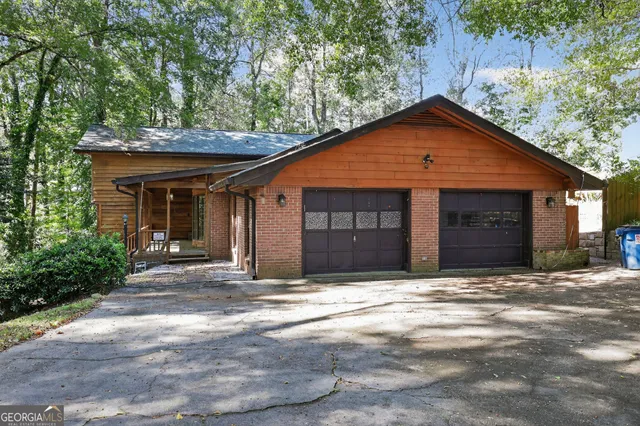 a front view of a house with yard and trees in the background