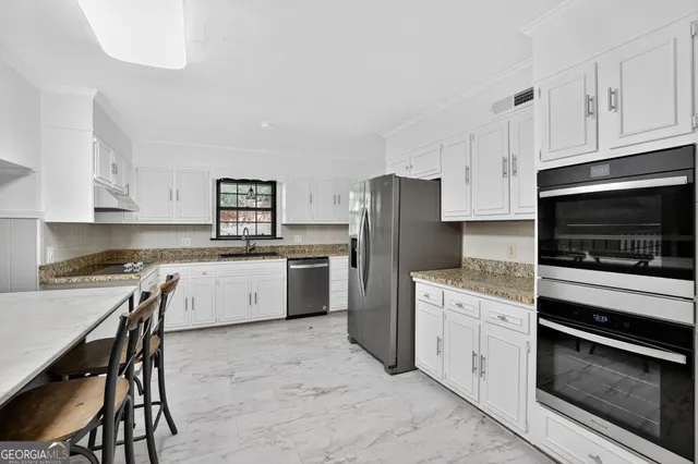 a kitchen with a stove a sink and a refrigerator