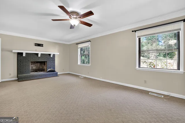 a view of an empty room with a fireplace and a window