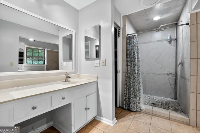 a bathroom with a shower sink and mirror
