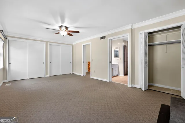 an empty room with closet and a ceiling fan