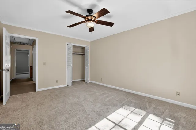 an empty room with fan and windows