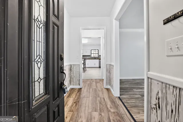 a view of a hallway with wooden floor and staircase