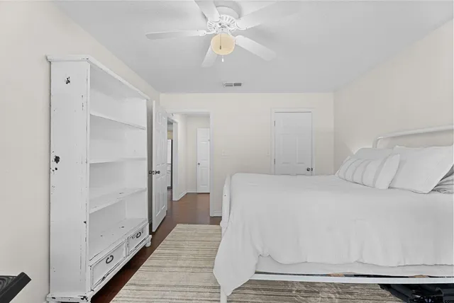 a spacious bedroom with a bed and a chandelier