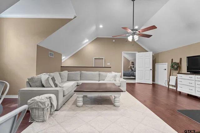 a living room with furniture a chandelier and a flat screen tv