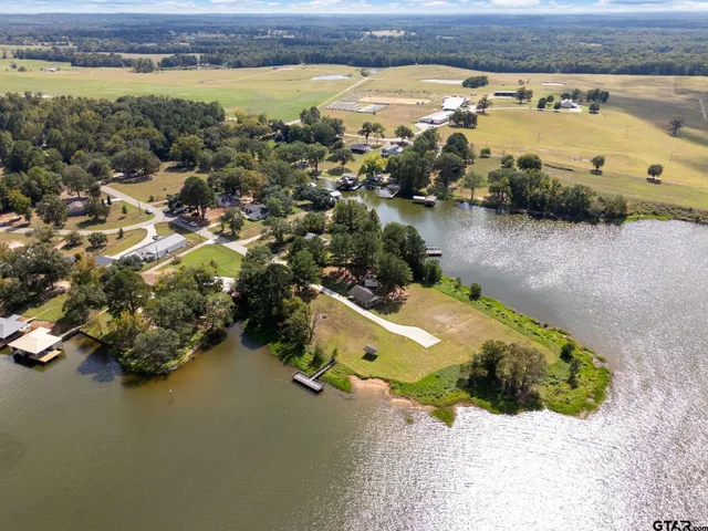 an aerial view of ocean and residential houses with outdoor space