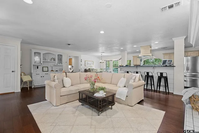 a living room with furniture white walls and kitchen view