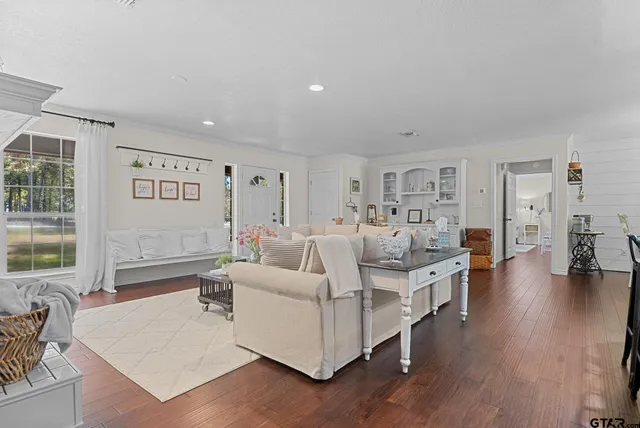a living room with furniture wooden floor and a large window