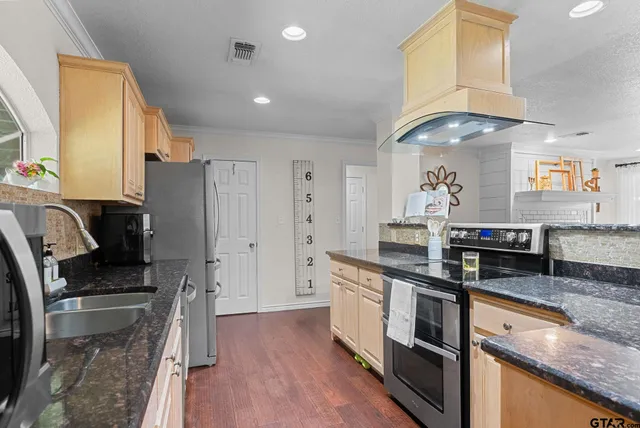 a kitchen with granite countertop a sink appliances and cabinets