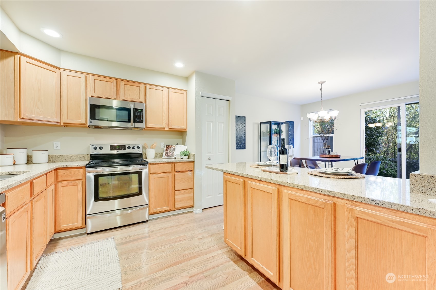 2201 192nd Street Southeast, Unit C3 Bothell, WA 98012 - Photo 7 of 26 a large kitchen with stainless steel appliances granite countertop a stove a sink and a microwave