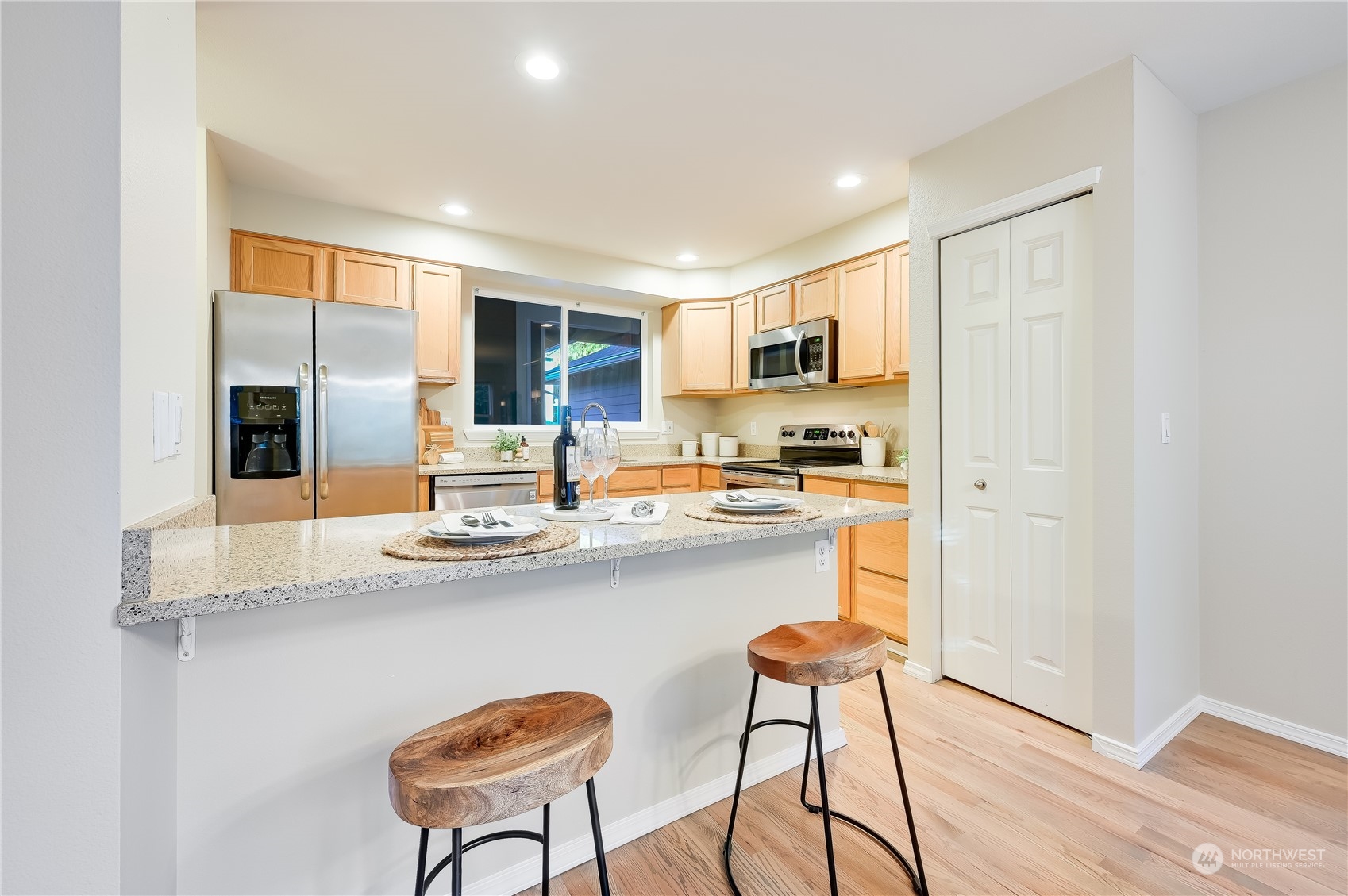 2201 192nd Street Southeast, Unit C3 Bothell, WA 98012 - Photo 8 of 26 a kitchen with stainless steel appliances granite countertop a stove a sink a refrigerator white cabinets and wooden floor