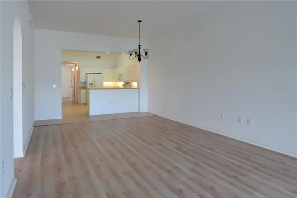 a view of empty room with wooden floor and floor to ceiling window