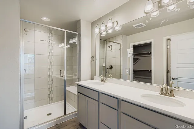 a bathroom with a shower sink and mirror