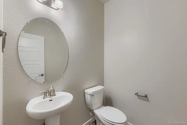 a bathroom with a toilet a sink and a mirror