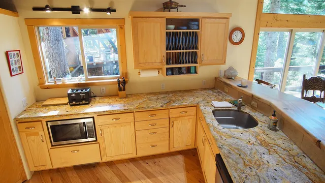 a kitchen with a stove a sink and a granite counter top