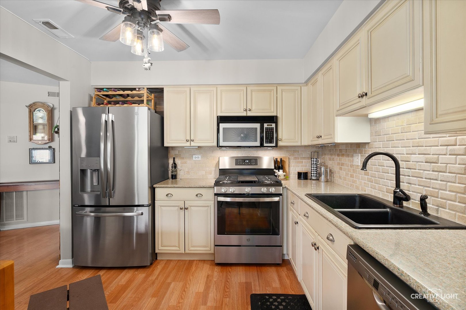 1703 Lakecliffe Drive, Unit D Wheaton, IL 60189 - Photo 8 of 20 a kitchen with stainless steel appliances granite countertop a refrigerator a sink dishwasher a stove and white cabinets with wooden floor