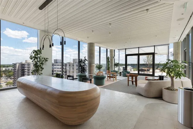 a living room with furniture and floor to ceiling windows