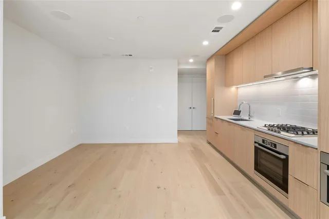 a view of kitchen with stove and cabinets