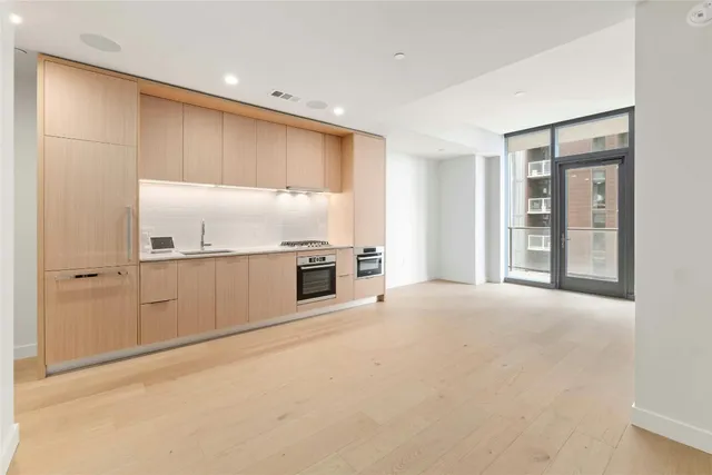 a view of an empty room with a kitchen