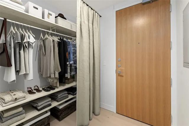 a view of walk in closet with clothes and shoes