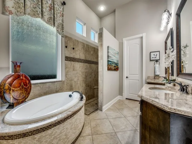 a bathroom with a granite countertop sink a mirror and shower