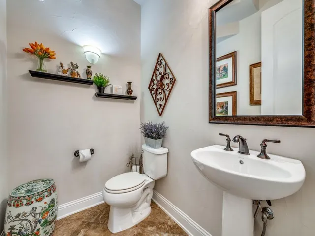 a bathroom with a toilet a sink and mirror