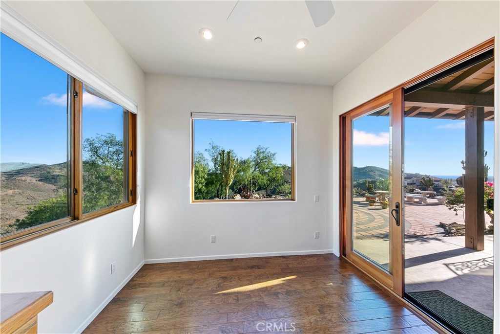 8400 Mipolomol Road Malibu, CA 90265 - Photo 18 of 58 an empty room with wooden floor and windows